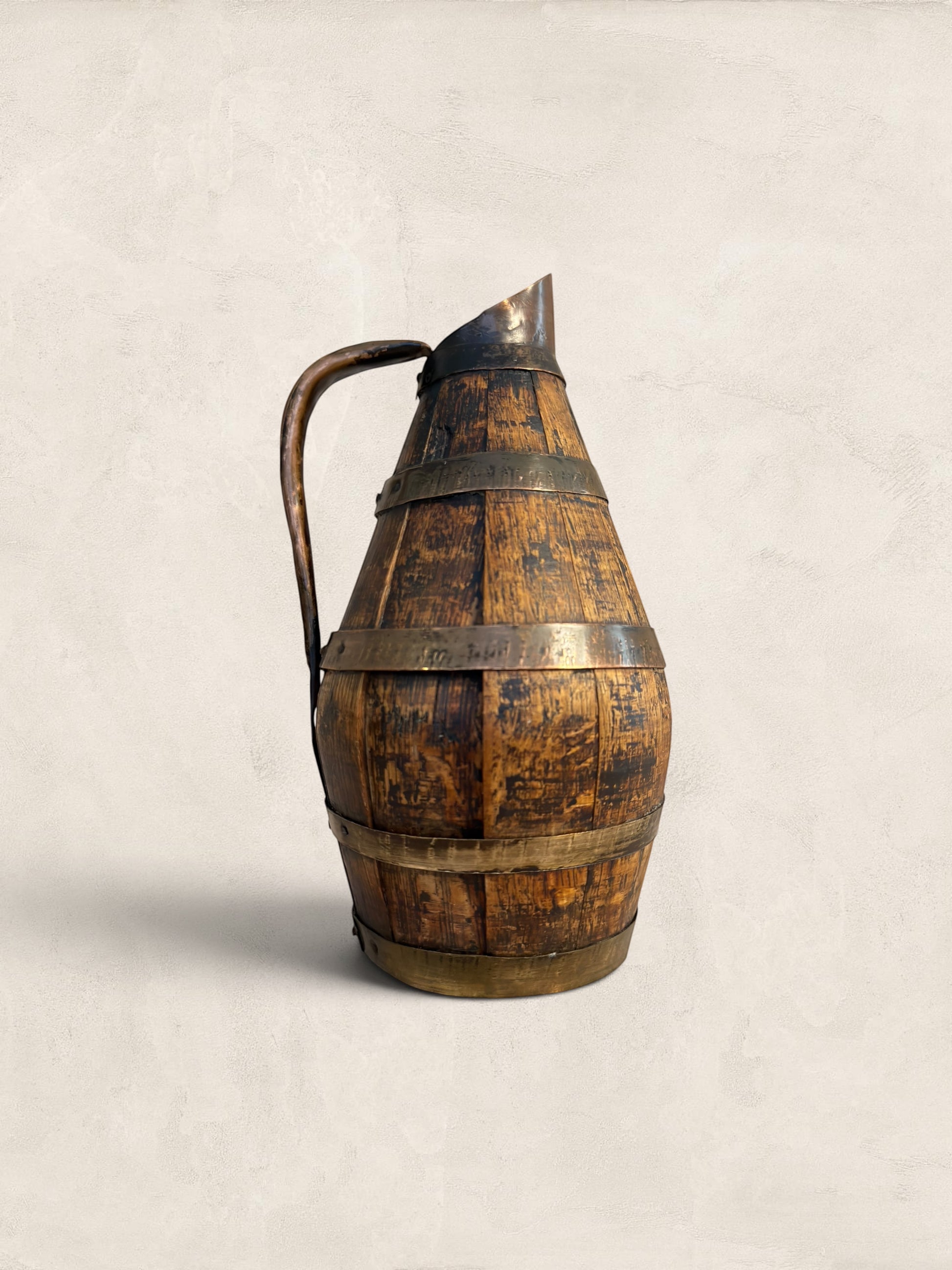 Stone and Relic antique barrel-shaped oak cider jug with copper banding and forged handle, decorative use only.