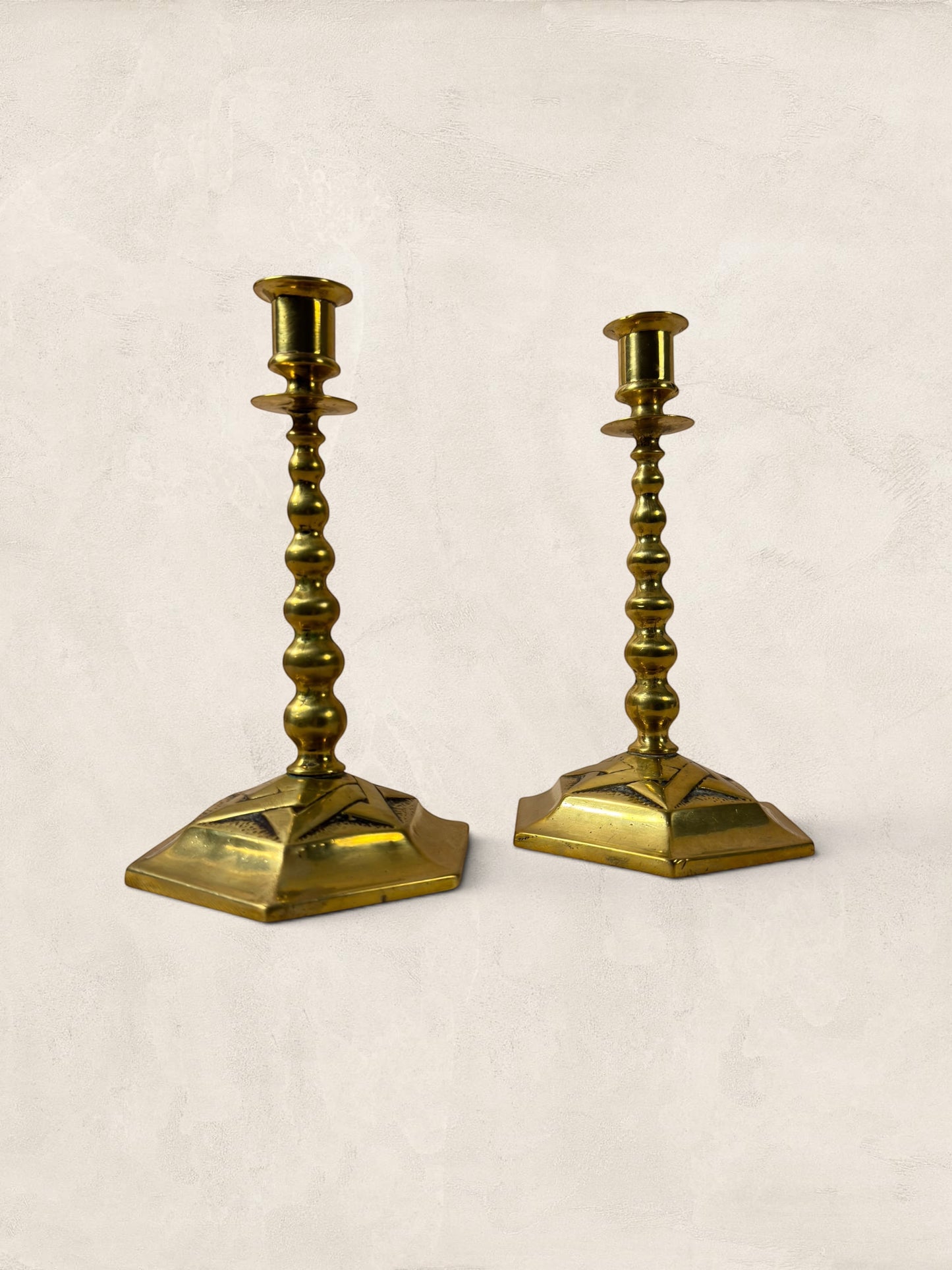 Stone and Relic pair of vintage brass hexagonal base candlesticks with aged patina and beaded stems.