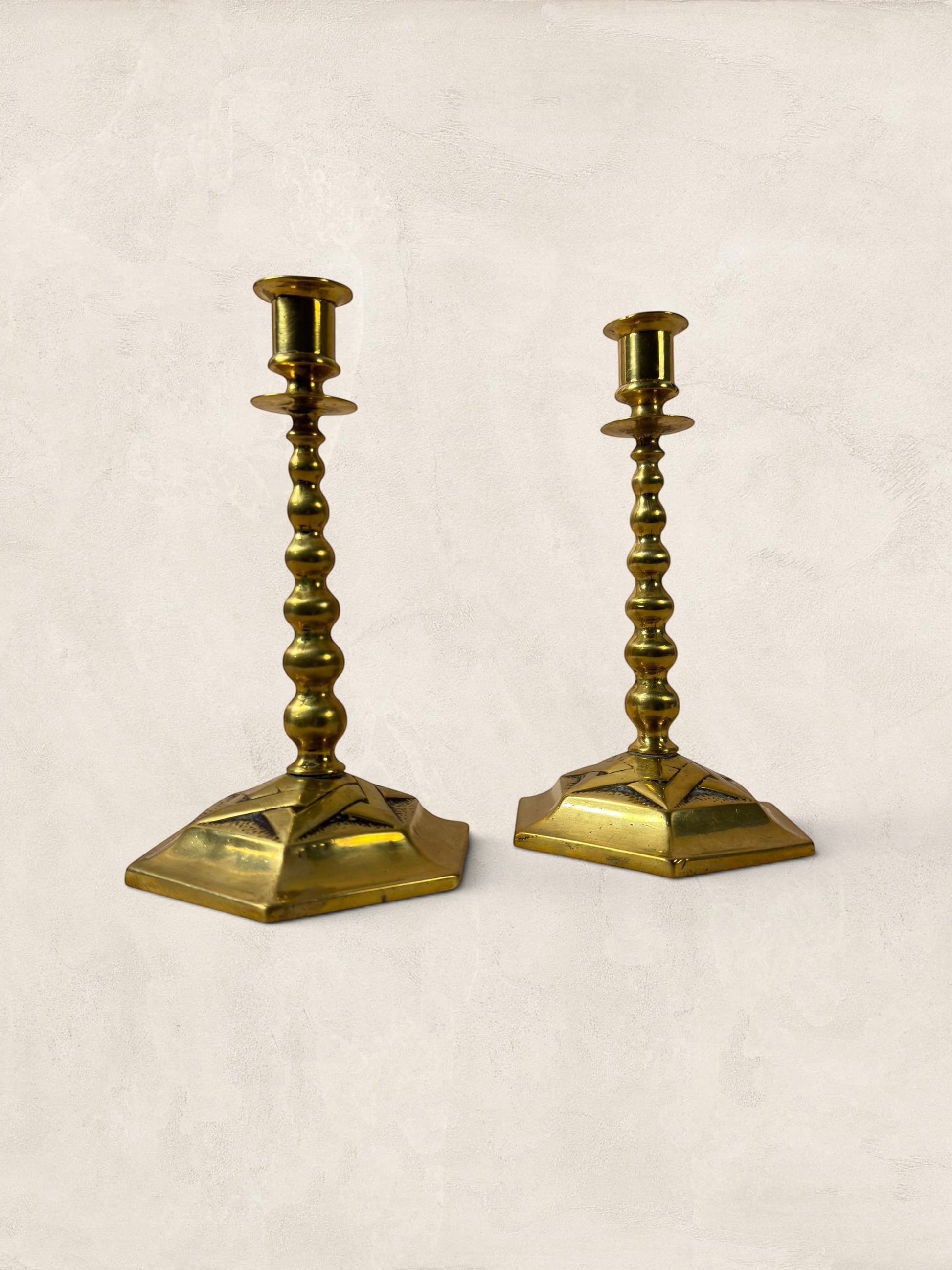 Stone and Relic pair of vintage brass hexagonal base candlesticks with aged patina and beaded stems.