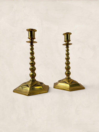 Stone and Relic pair of vintage brass hexagonal base candlesticks with aged patina and beaded stems.