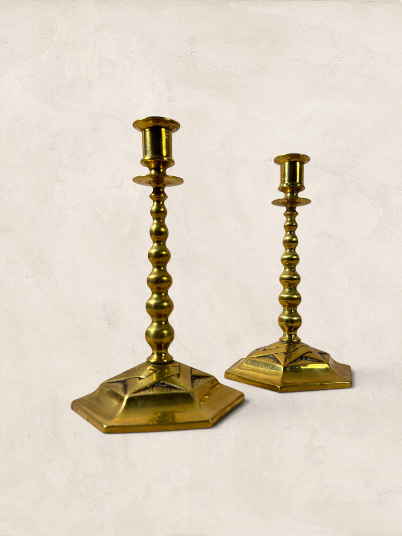 Stone and Relic pair of vintage brass hexagonal base candlesticks with beaded stems and aged patina.