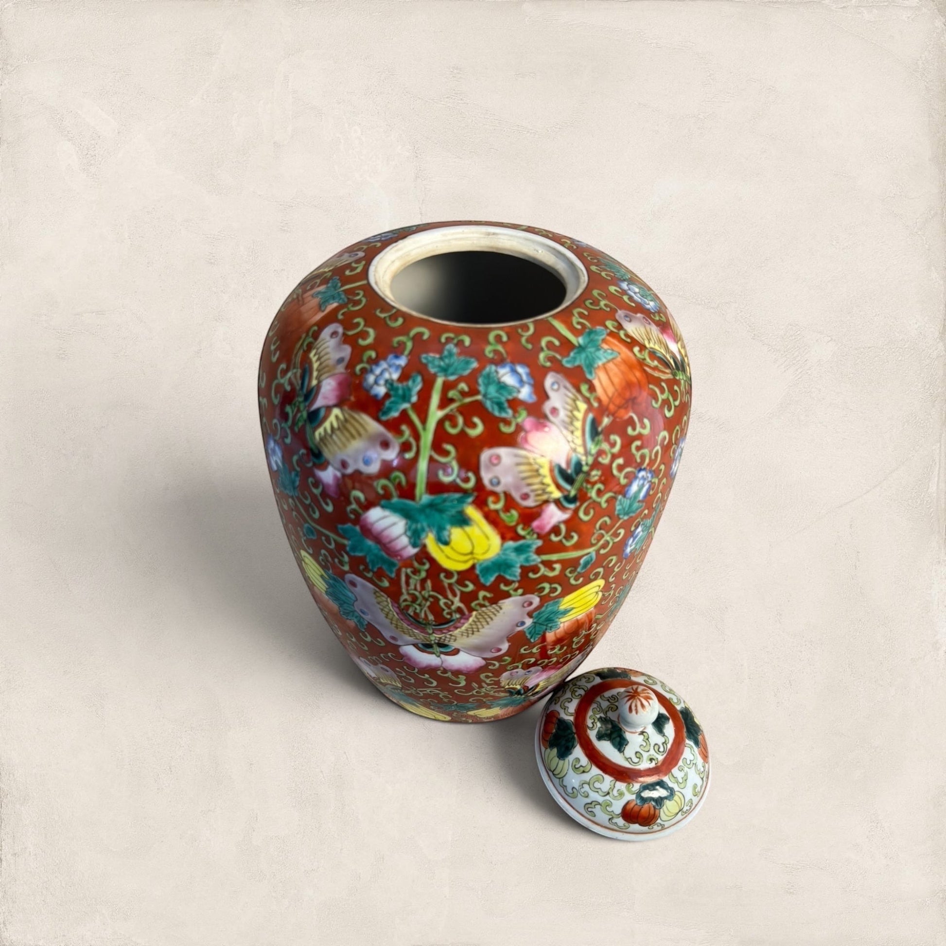 Stone and Relic decorative ceramic ginger jar with butterfly and floral motif in red, yellow, pink, green, and blue.